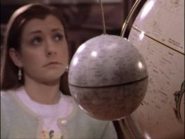 Willow listening to Giles as he uses a globe in Phases
